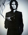 A drawing created as part of Inktober 2021 for the prompt "Suit". Features Atsushi Sakurai, vocalist of the band Buck-Tick, wearing an all black suit and holding a smoking kiseru pipe.